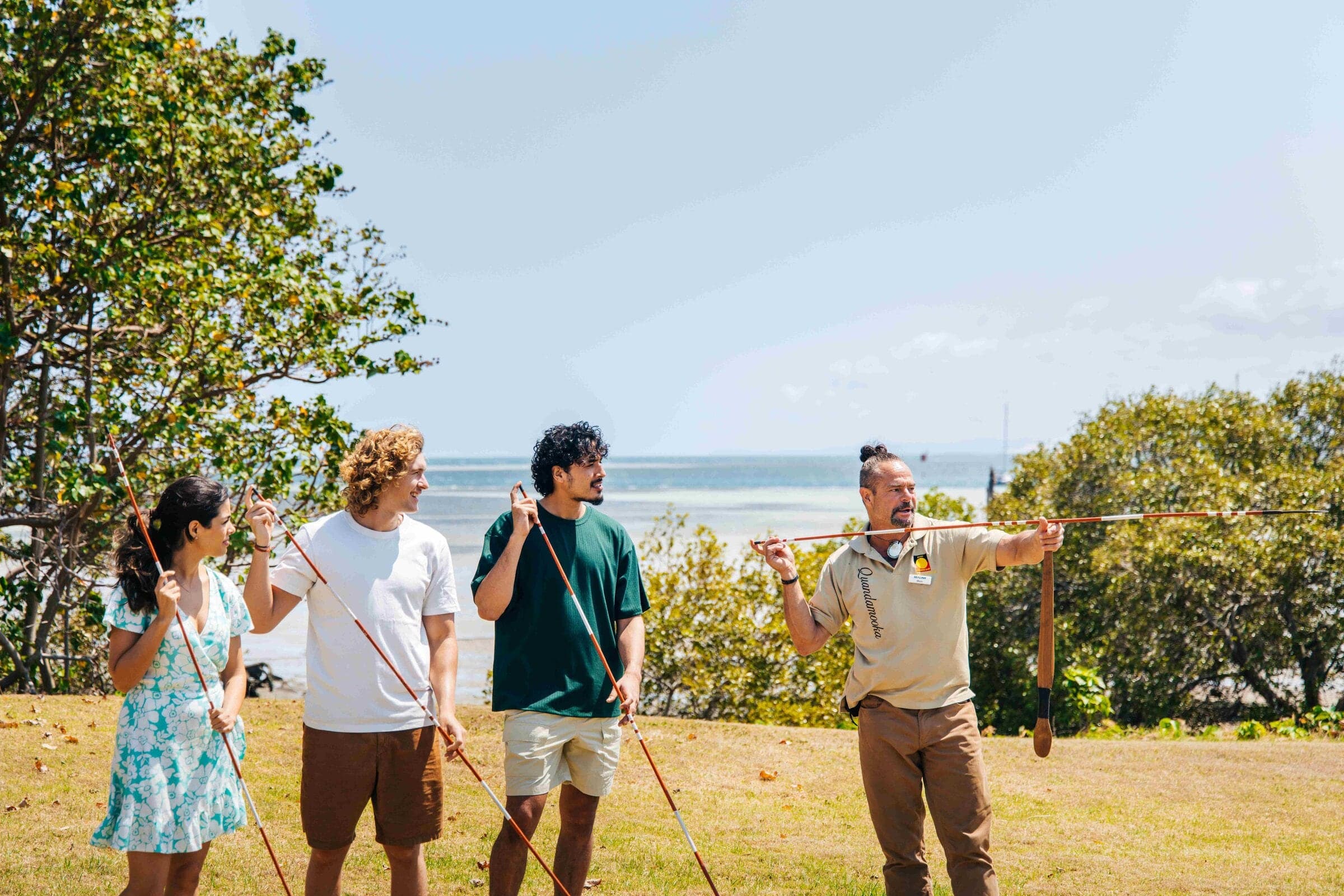 Matt Burns demonstrates spear throwing to tour guests on the foreshore at North Stradbroke Island